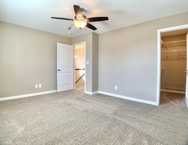a view of an empty room and a ceiling fan