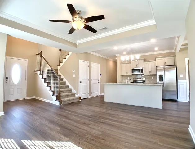 a view of kitchen with stainless steel appliances kitchen island wooden floor and ceiling fan