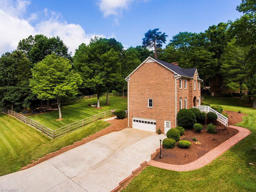 5001 Leadenhall Road Oak Ridge, NC 27310 - Photo 3 of 30 Beautiful mature landscaping with spacious fenced yard and side entrance basement garage!