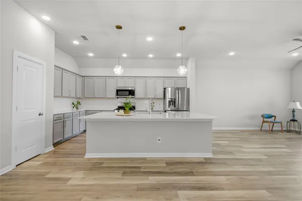 a kitchen with stainless steel appliances a refrigerator sink and microwave