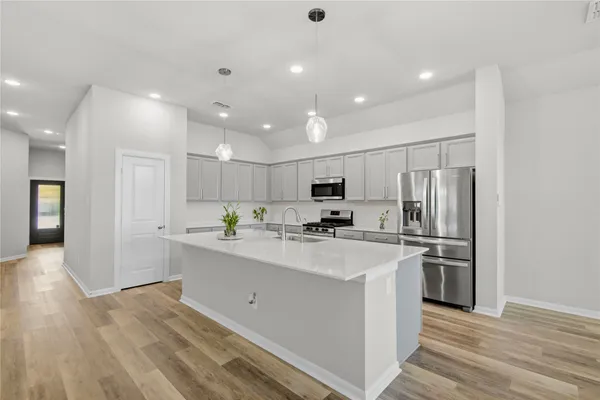 a kitchen with a sink stove top oven and microwave