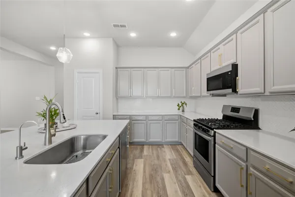 a kitchen with a refrigerator stove and white cabinets