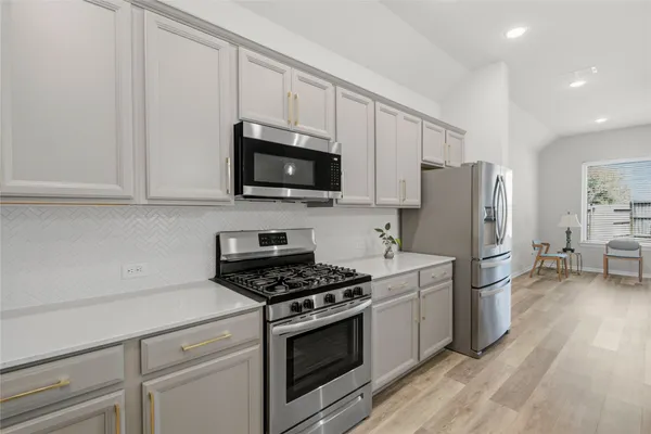 a view of a kitchen counter top space with sink and wooden floor