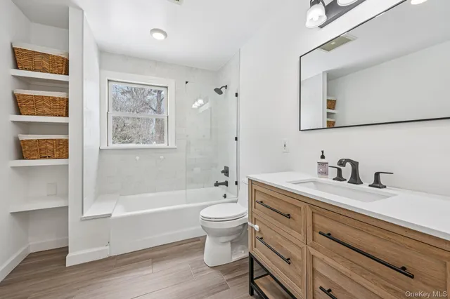 a bedroom with a bed a chair and a dresser next to a window