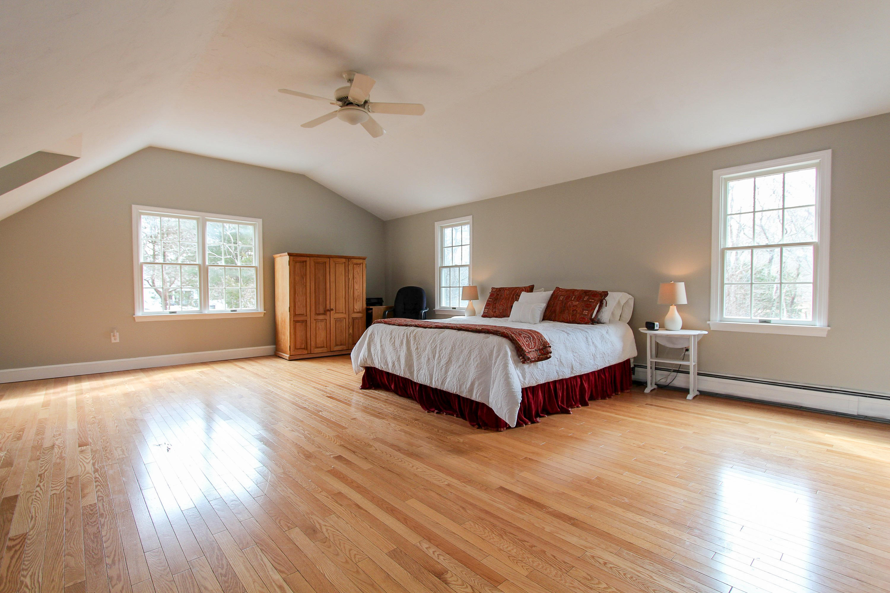29 Schooner Drive Cotuit, MA 02635 - Photo 21 of 35 a spacious bedroom with a large bed chandelier and a window