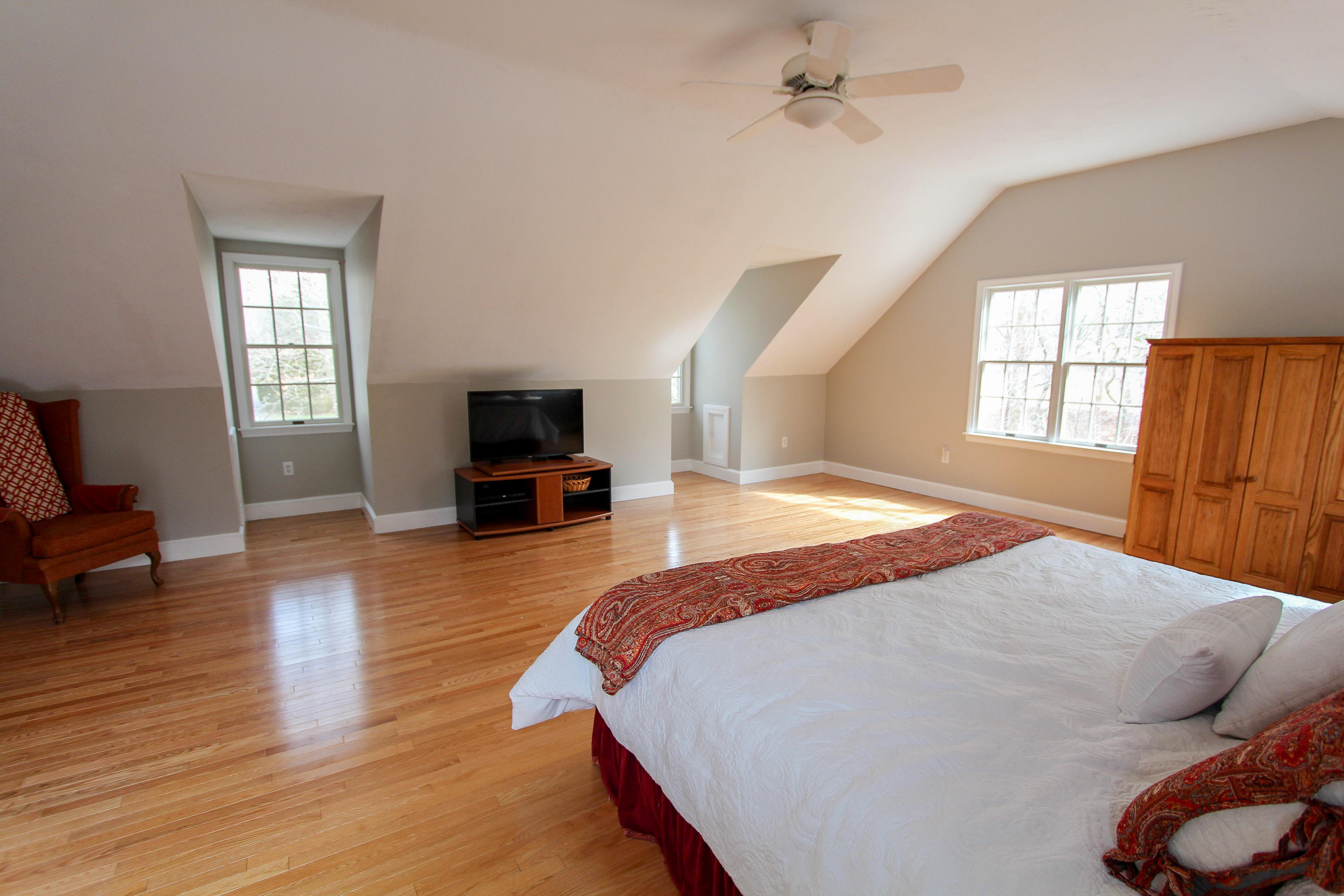 29 Schooner Drive Cotuit, MA 02635 - Photo 24 of 35 a spacious bedroom with a bed and wooden floor