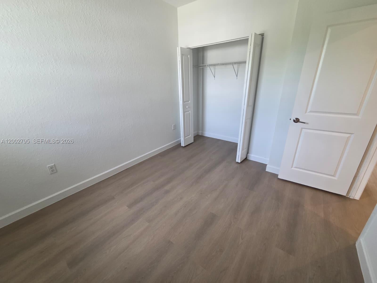 1844 Southeast 27th Street Homestead, FL 33035 - Photo 13 of 23 an empty room with wooden floor and closet