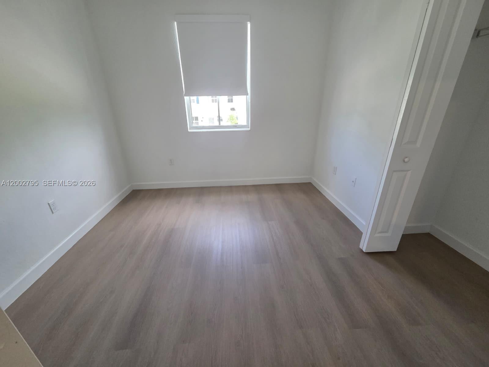 1844 Southeast 27th Street Homestead, FL 33035 - Photo 14 of 23 an empty room with wooden floor and windows
