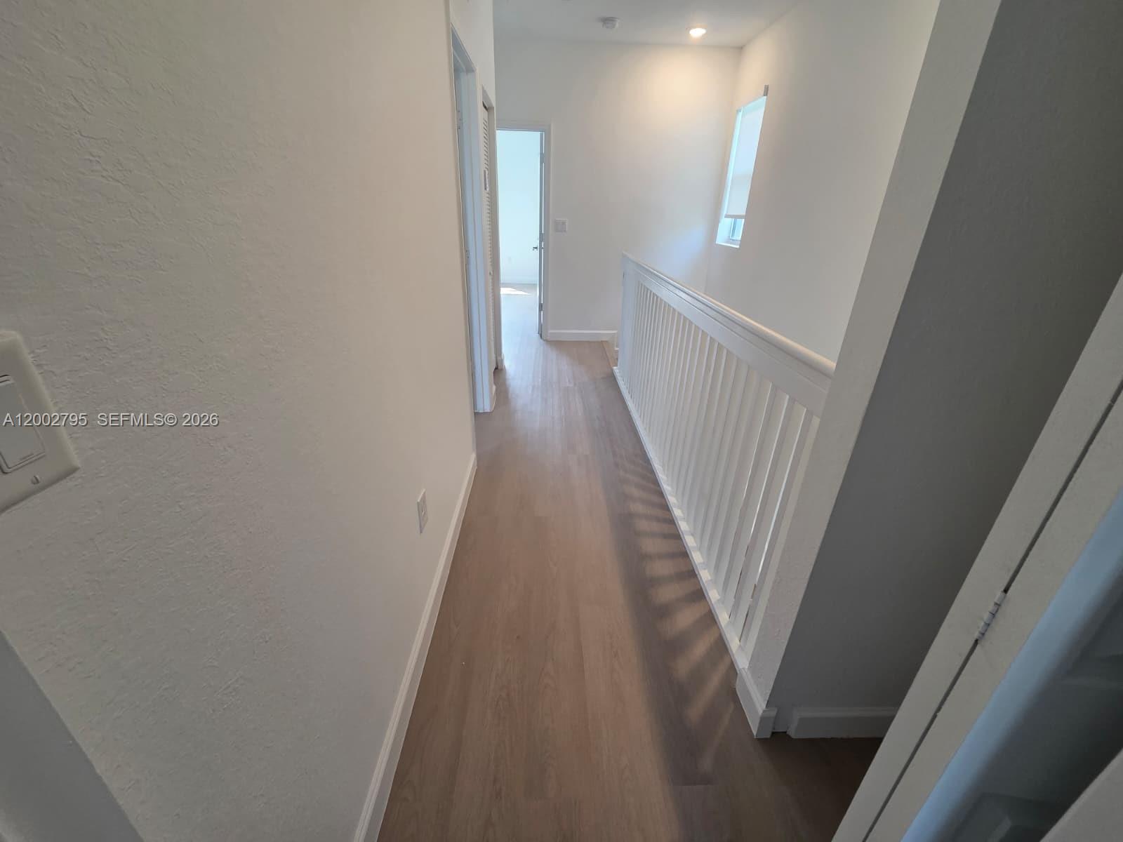1844 Southeast 27th Street Homestead, FL 33035 - Photo 16 of 23 a view of a hallway with wooden floor and staircase