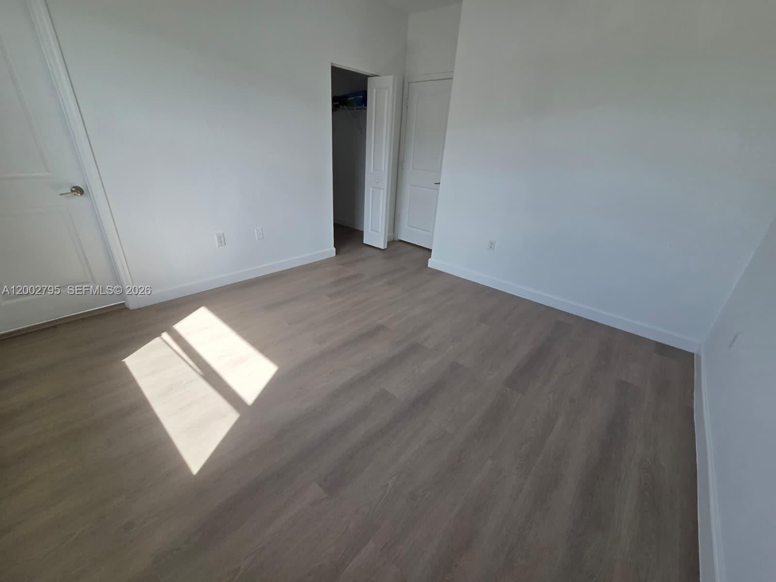 1844 Southeast 27th Street Homestead, FL 33035 - Photo 19 of 23 an empty room with wooden floor and windows