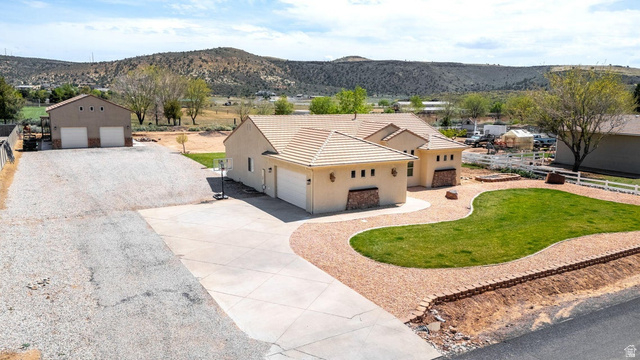 7776 Wagon Road East St. George, UT 84770 - Photo 3 of 76 View of front facade featuring stucco siding, driveway, a mountain view, and a front yard