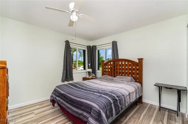 a bedroom with a large bed chandelier and a window
