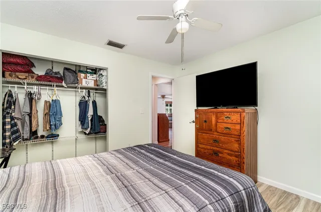 a bedroom with a bed and a flat tv screen on dresser