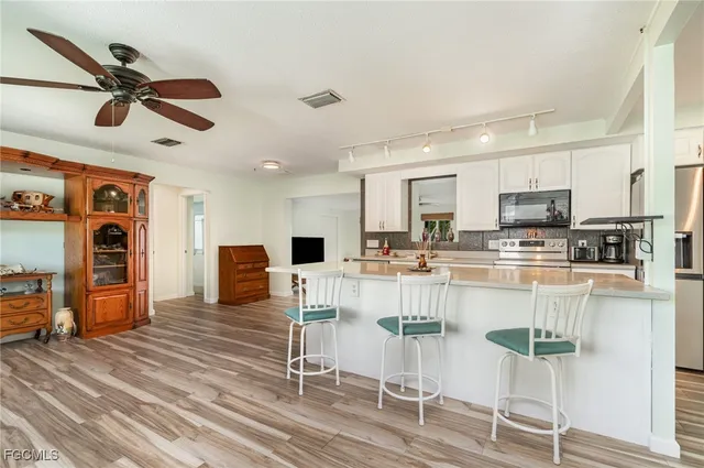 a kitchen with stainless steel appliances kitchen island granite countertop a refrigerator and microwave