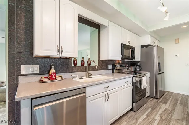 a kitchen with a sink stove top oven and refrigerator
