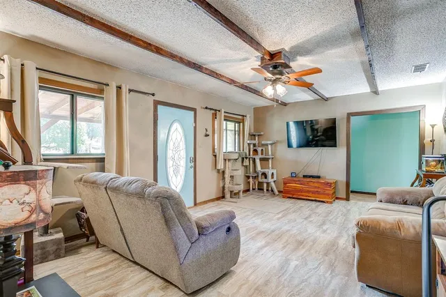 a living room with furniture a flat screen tv and wooden floor