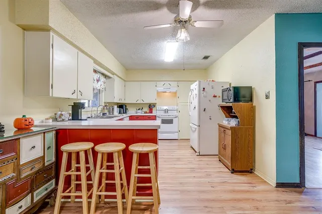 a kitchen with a sink appliances and cabinets