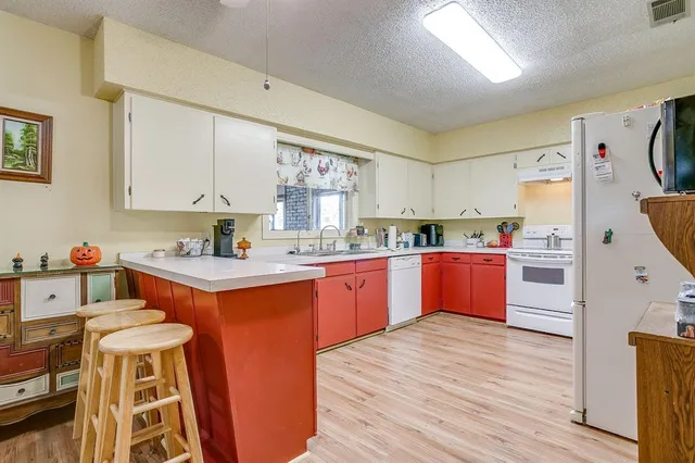 a kitchen with stainless steel appliances kitchen island wooden floors and wooden cabinets