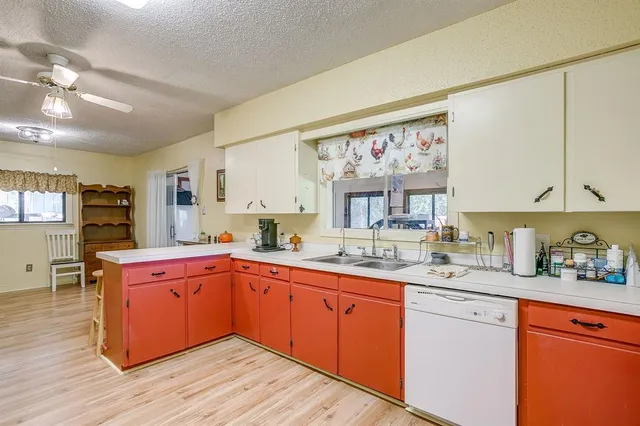 a kitchen with a sink cabinets and wooden floor