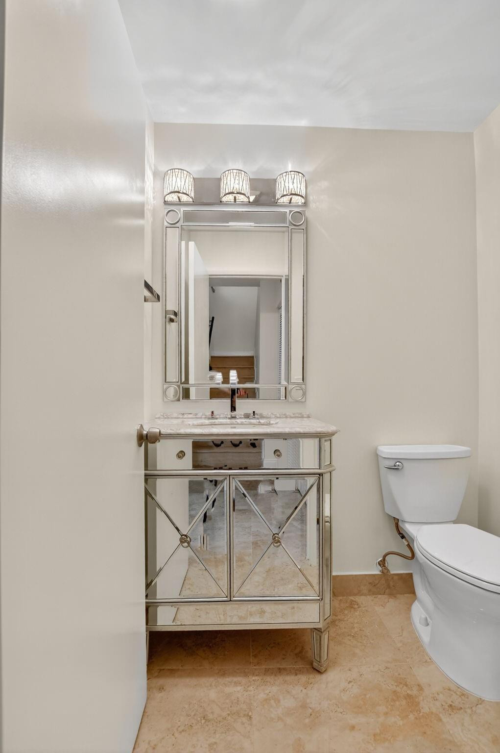 21476 Juego Circle, Unit 8C Boca Raton, FL 33433 - Photo 20 of 54 a bathroom with a sink a mirror and a toilet