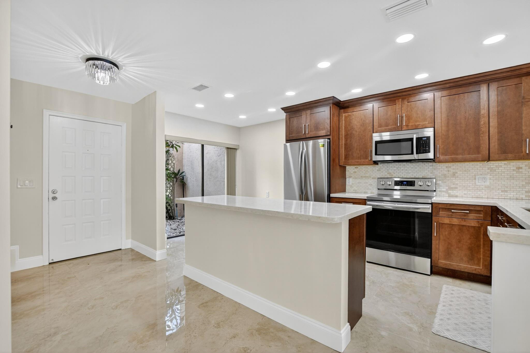 21476 Juego Circle, Unit 8C Boca Raton, FL 33433 - Photo 2 of 54 a kitchen with stainless steel appliances granite countertop a refrigerator stove and microwave
