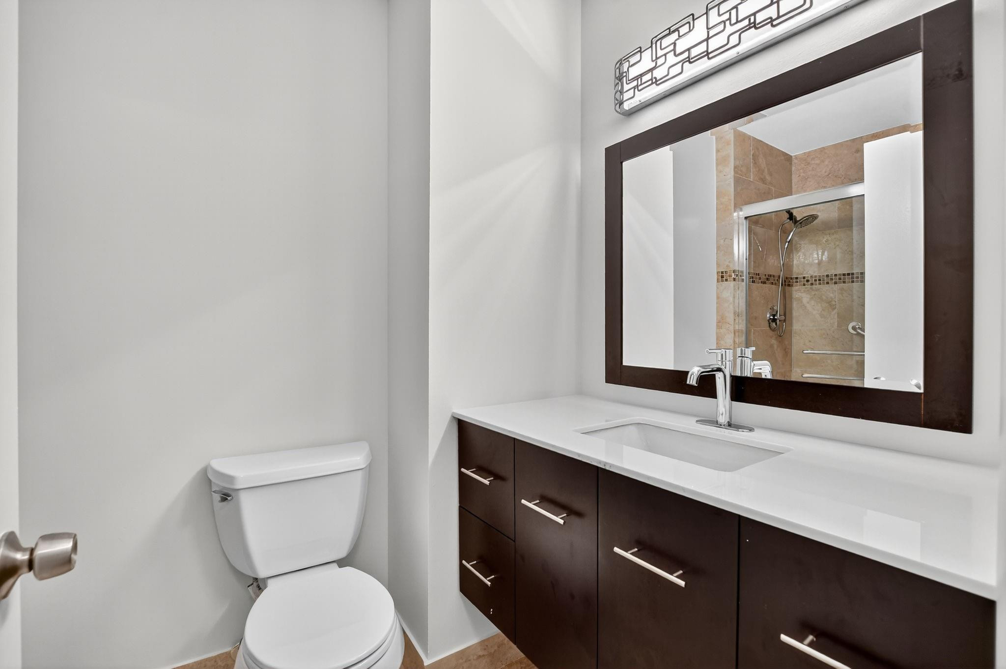 21476 Juego Circle, Unit 8C Boca Raton, FL 33433 - Photo 37 of 54 a bathroom with a toilet a sink and mirror