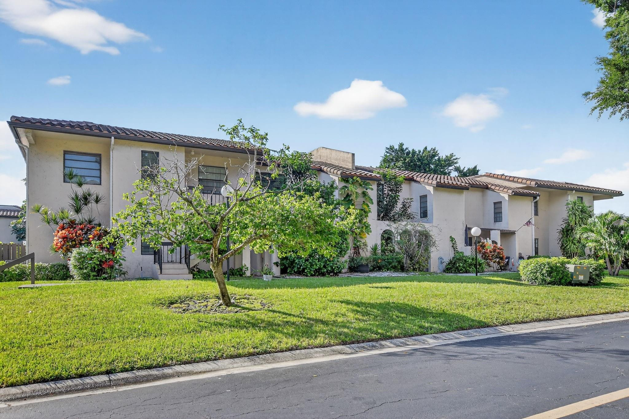21476 Juego Circle, Unit 8C Boca Raton, FL 33433 - Photo 44 of 54 a view of a house with a yard and plants