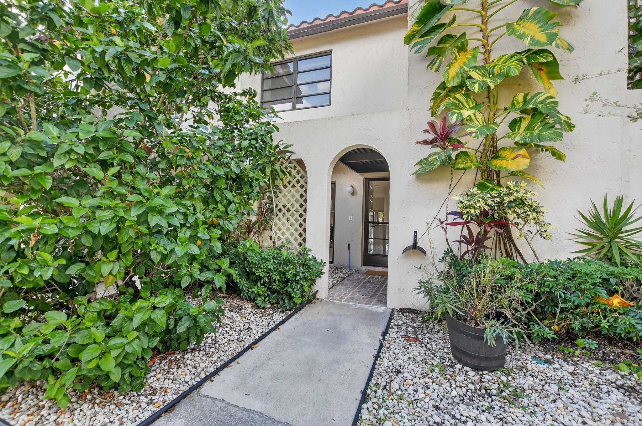 21476 Juego Circle, Unit 8C Boca Raton, FL 33433 - Photo 45 of 54 a front view of a house with a yard