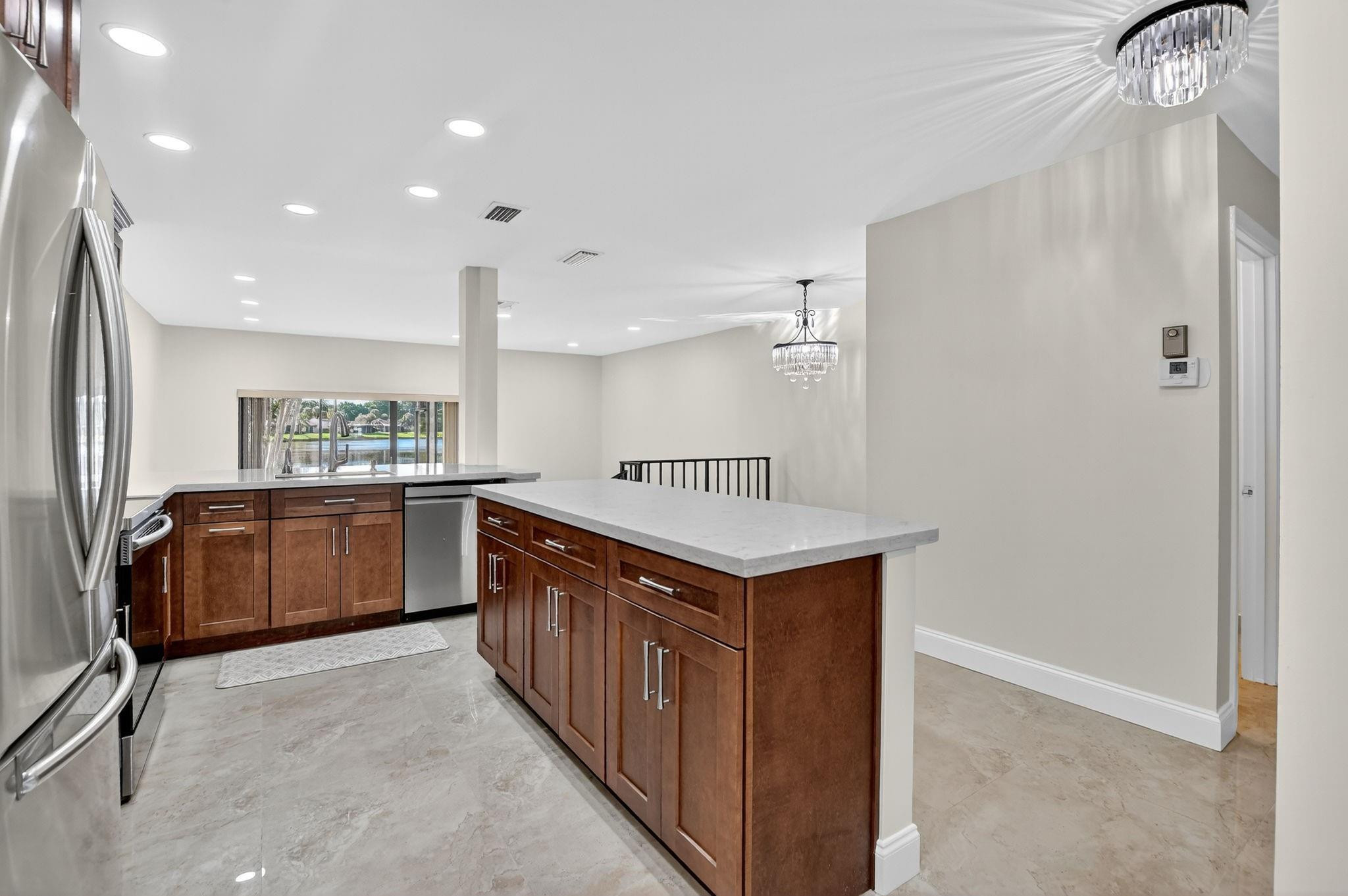 21476 Juego Circle, Unit 8C Boca Raton, FL 33433 - Photo 6 of 54 a kitchen with stainless steel appliances a sink and a refrigerator