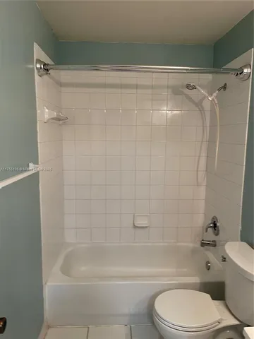 a bathroom with a shower a toilet and a bath tub