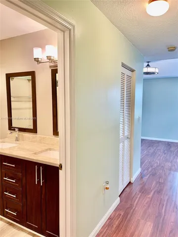 a bathroom with a granite countertop sink toilet and mirror