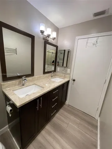 a bathroom with a double vanity sink and a mirror