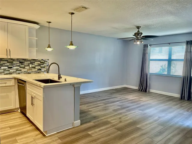 a kitchen with a sink cabinets and wooden floor