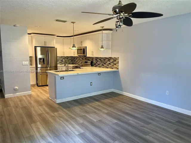 a kitchen with stainless steel appliances granite countertop a refrigerator and a stove top oven