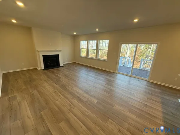 an empty room with wooden floor and fireplace