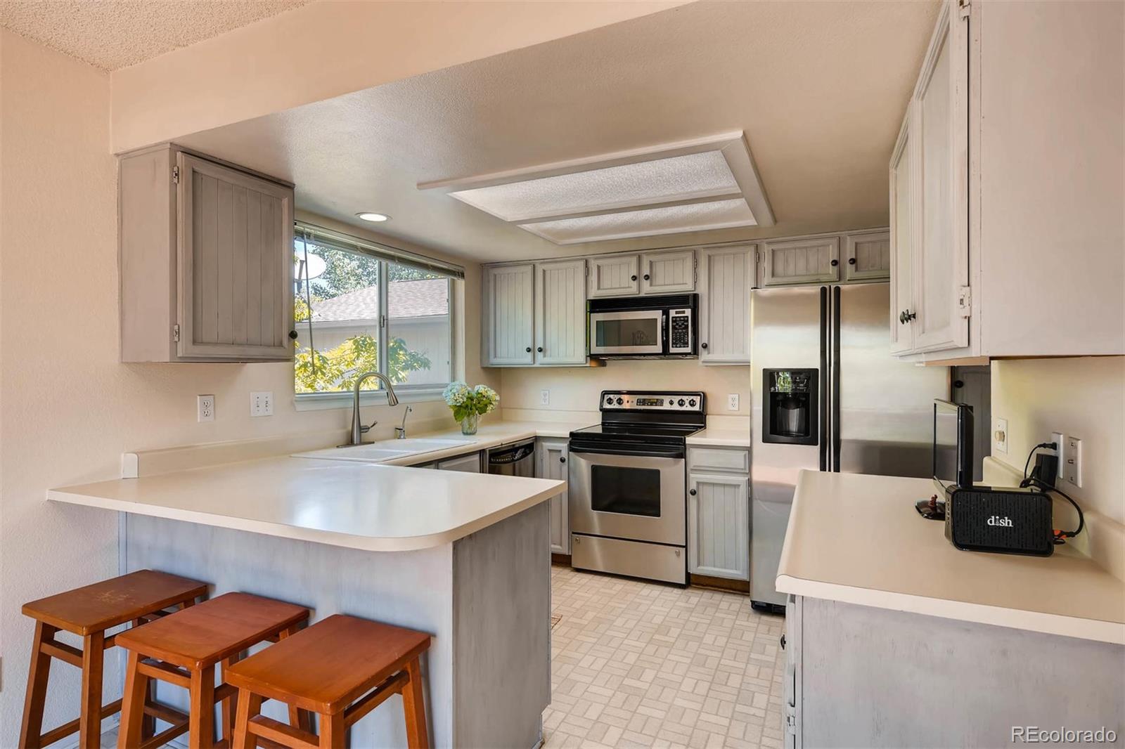 69 Prairie Ridge Road Highlands Ranch, CO 80126 - Photo 6 of 28 a kitchen with a sink a stove a refrigerator cabinets and chairs
