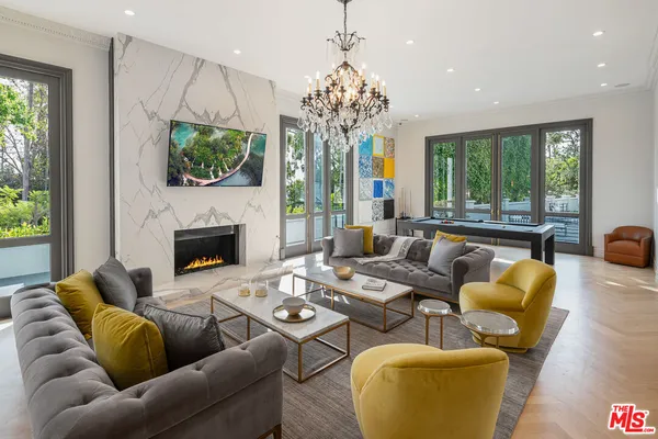 a living room with furniture fireplace and large windows