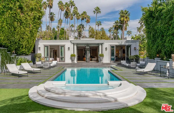 a view of a house with swimming pool and sitting area