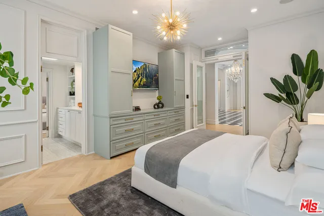 a bedroom with bed and a chandelier