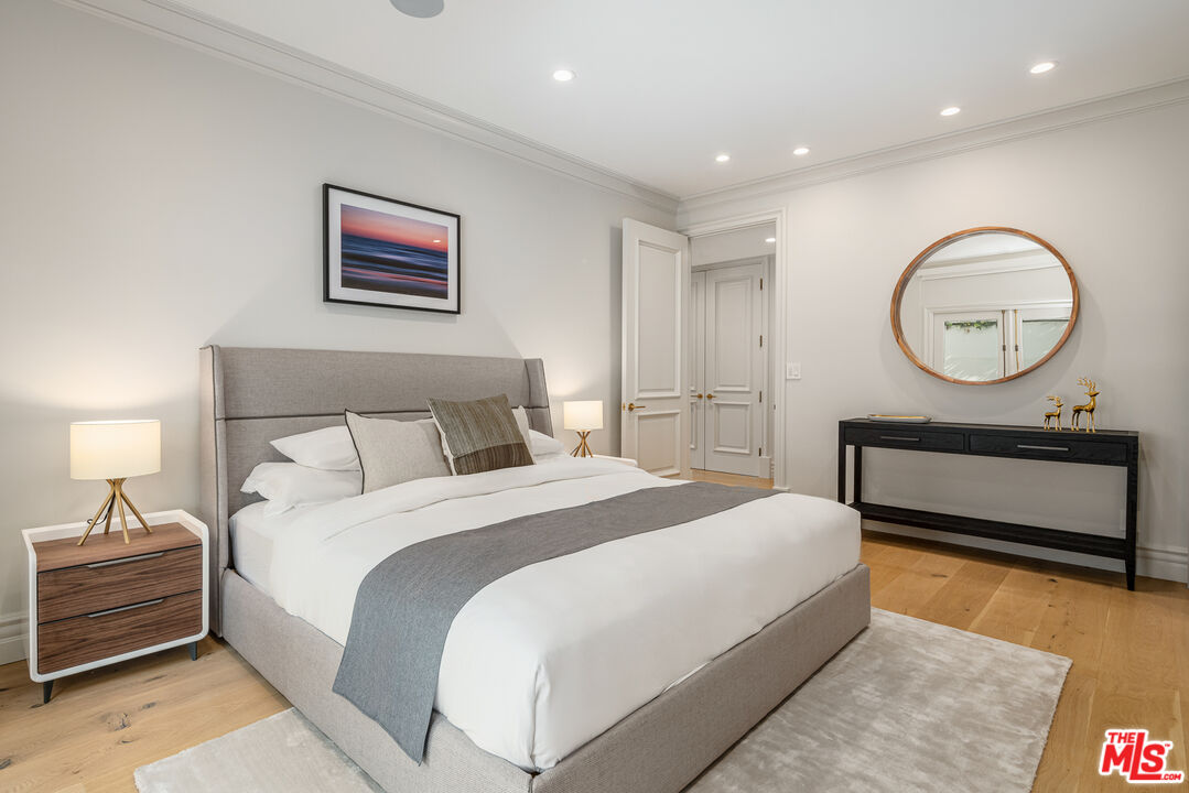 402 Doheny Road Beverly Hills, CA 90210 - Photo 30 of 55 a bedroom with bed and a chandelier