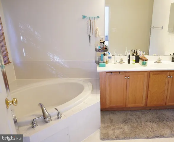a bathroom with a bathtub sink and mirror