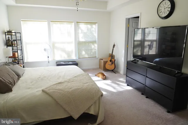a bedroom with a bed and a large window