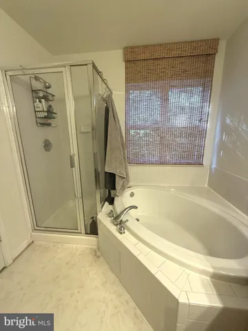 a spacious bathroom with a bathtub and a shower