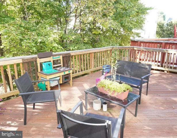 a balcony with wooden floor and outdoor seating