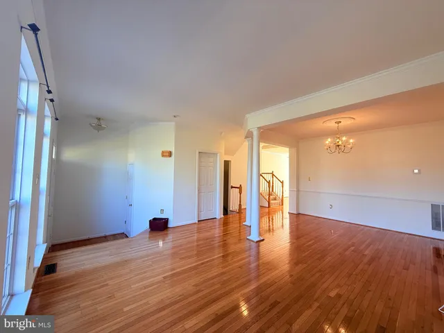 a view of empty room with wooden floor