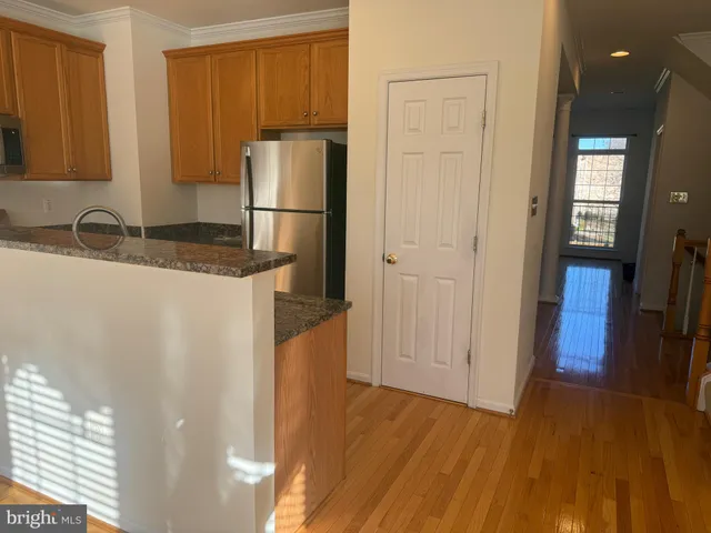 a kitchen with granite countertop a refrigerator and a sink