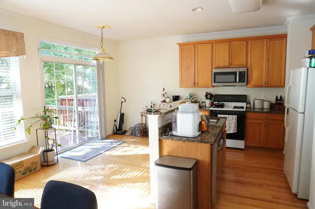 a kitchen with kitchen island granite countertop a sink cabinets and stainless steel appliances