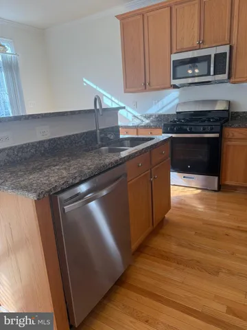 a kitchen with stainless steel appliances granite countertop a stove a sink and a microwave