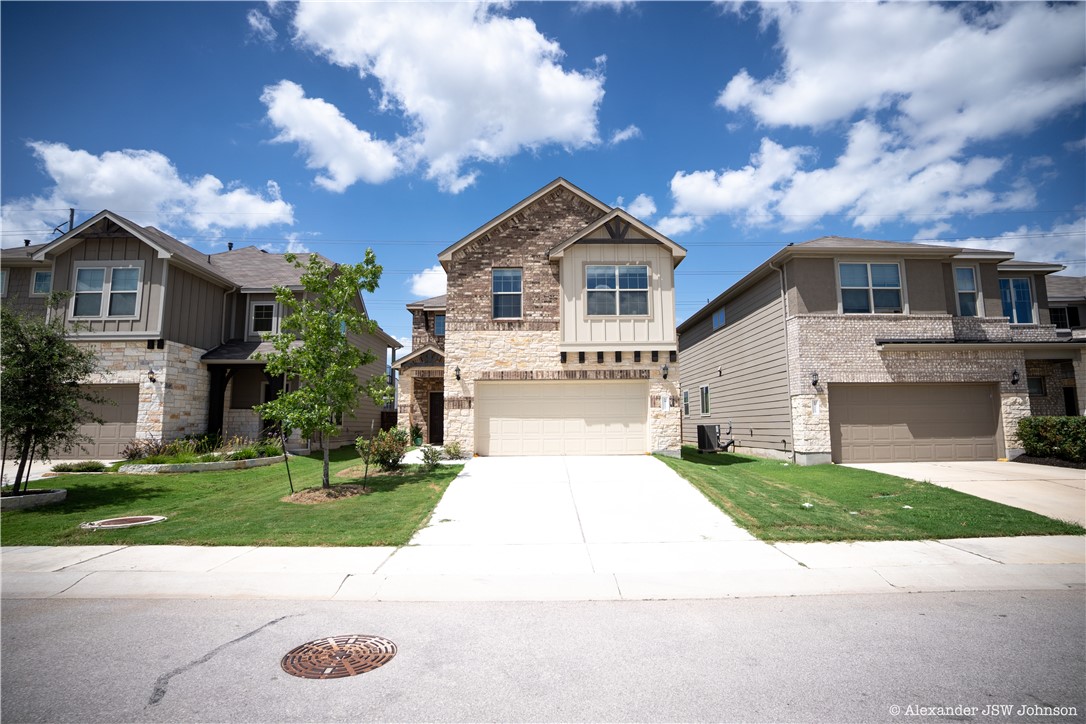a front view of a house with a yard and garage
