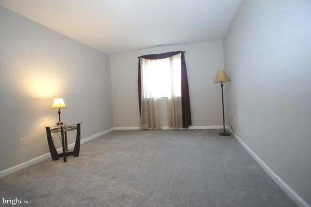 an empty room with chandelier fan